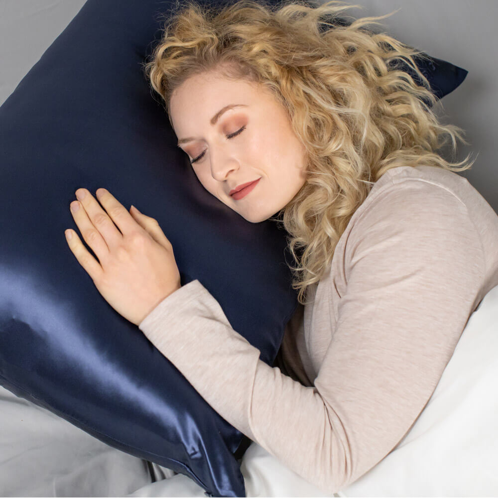 Woman sleeping on a blue Blissy silk pillowcase