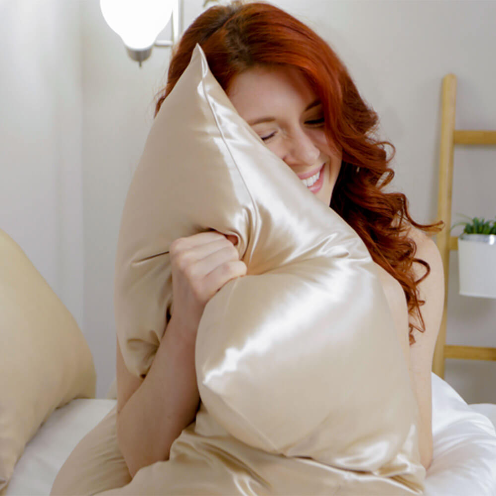Woman hugging a champagne Blissy silk pillowcase