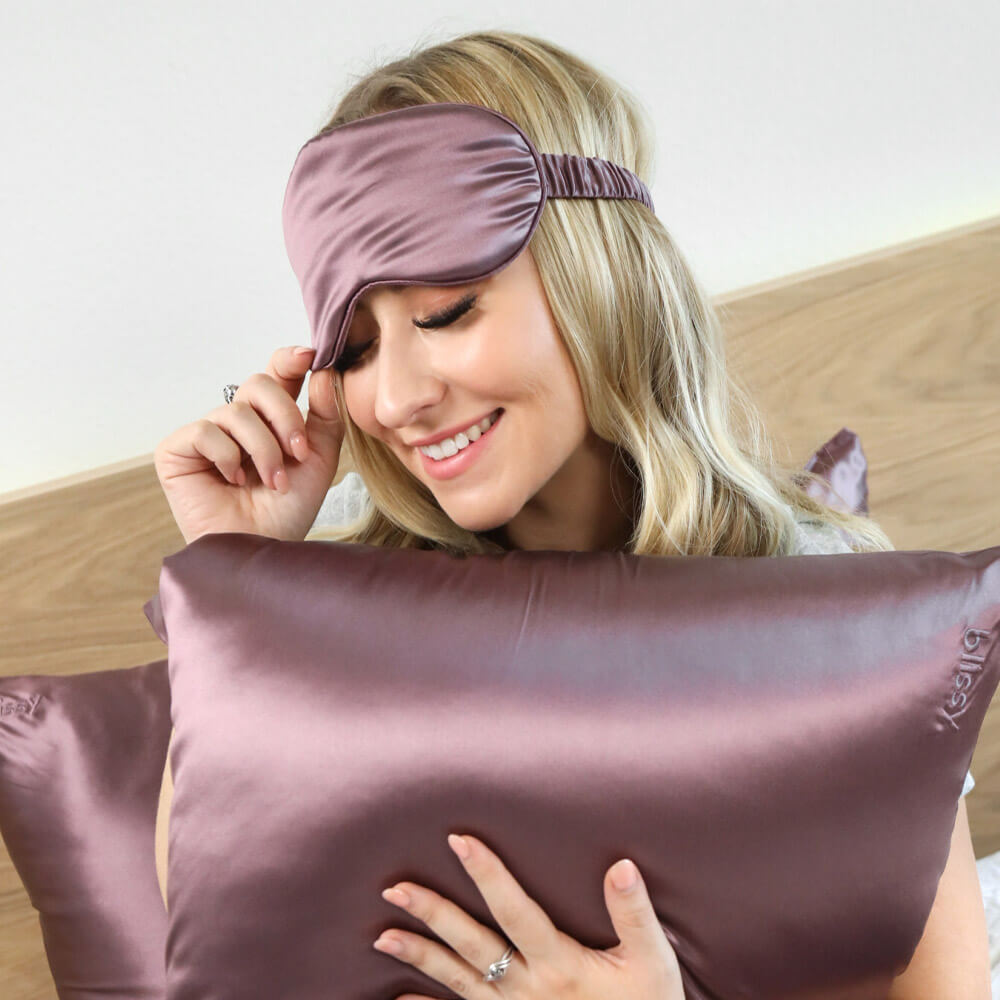 Woman hugging a plum Blissy silk pillowcase