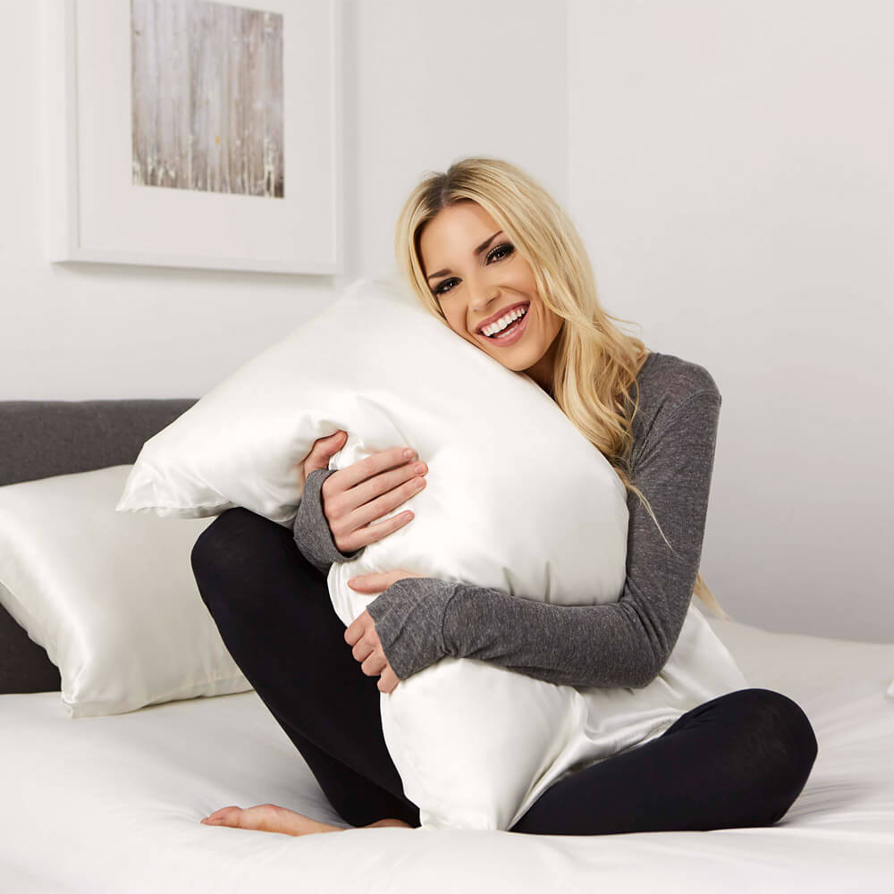 Woman hugging a white Blissy silk pillowcase